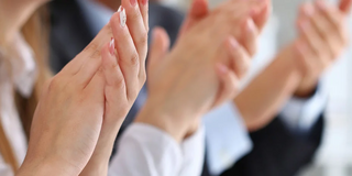 Mehrere Hände von Frauen und Männern applaudieren.